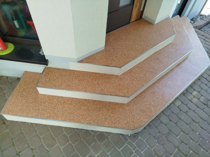 Eingangstreppe mit Steinteppich-Belag in Terrakotta und abgerundeten Stufen