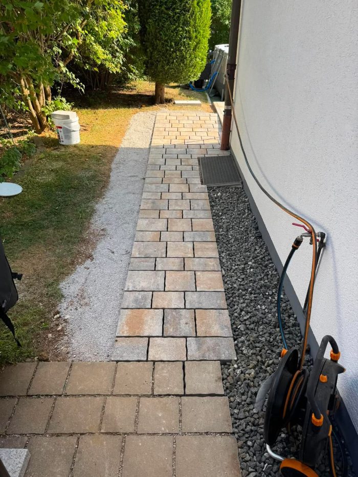 Gepflasterter Gehweg entlang der Hauswand mit Anschluss an den Garten